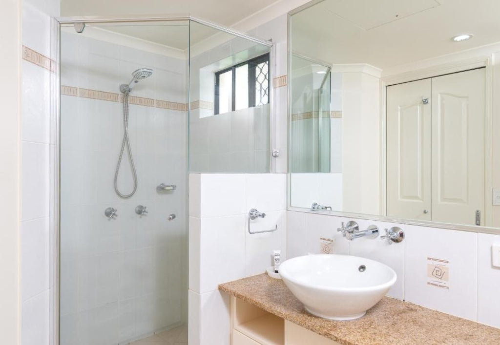 Bathroom with shower, sink, and mirror. Meridian Port Douglas
