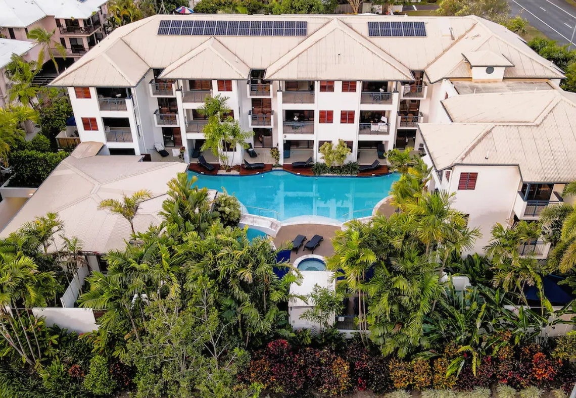 Aerial view of Meridian Resort Port Douglas with a pool surrounded by greenery