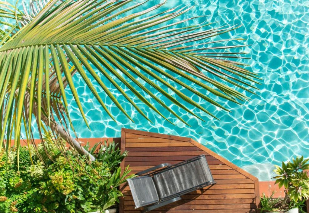 Palm leaf over Meridian Port Douglas a pool with a lounge chair on a wooden deck